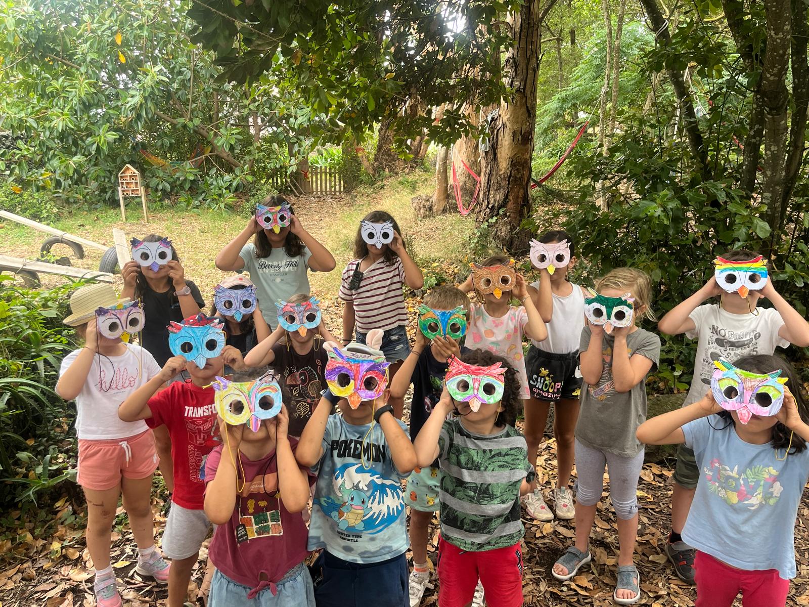 Grupo de crianças com máscaras de coruja feitas por elas